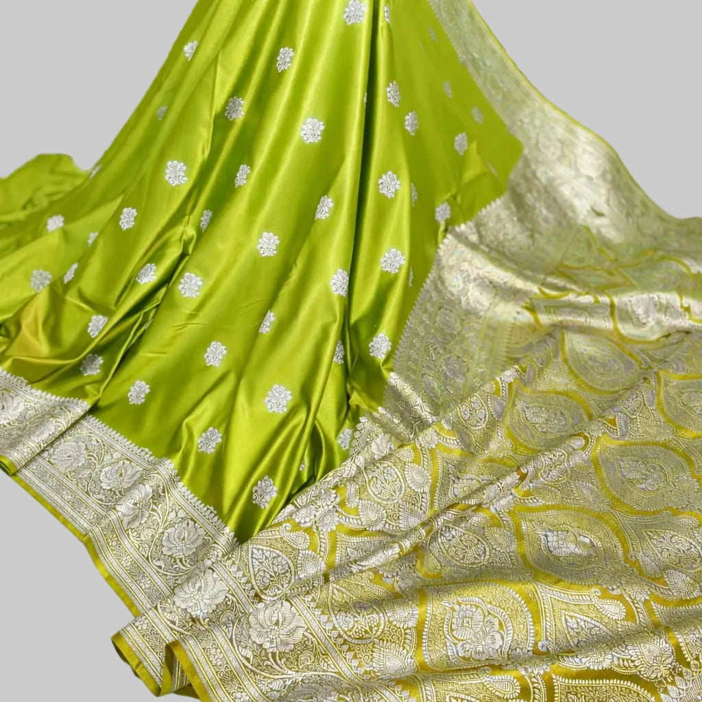Green saree with silver patterns on a white fabric background