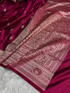 Maroon saree with intricate gold patterns on a white background