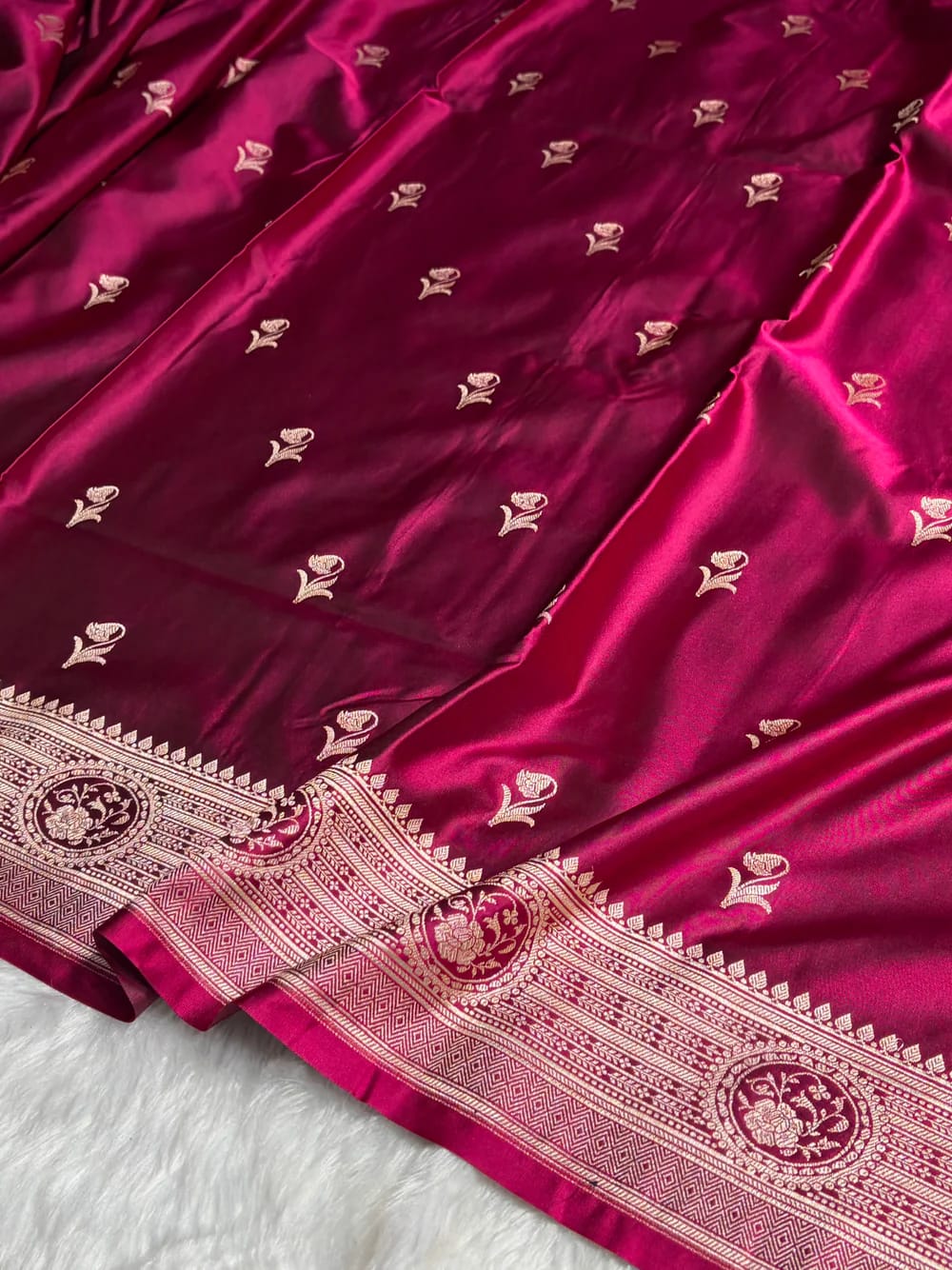 Maroon saree with gold embroidery on a white background