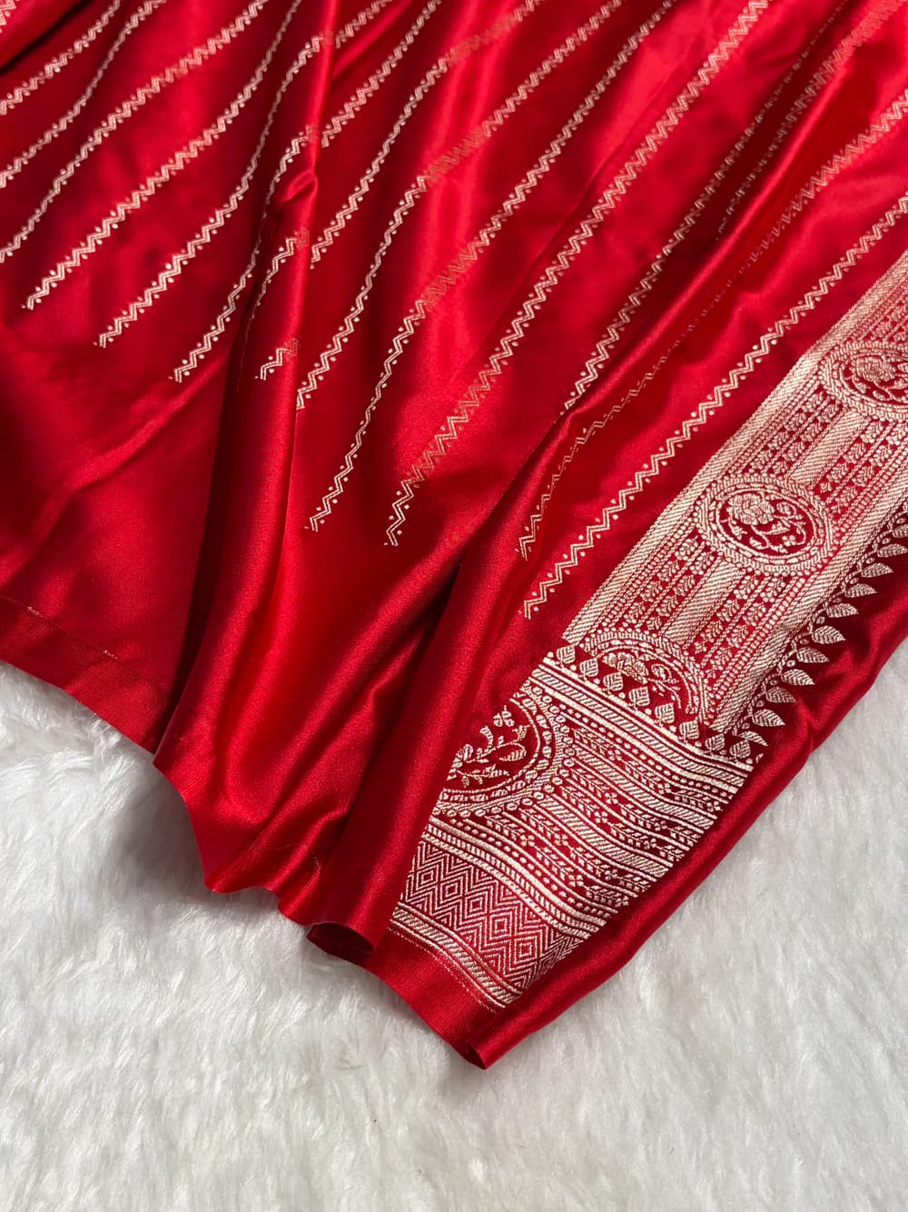 Red fabric with white intricate patterns on a white background