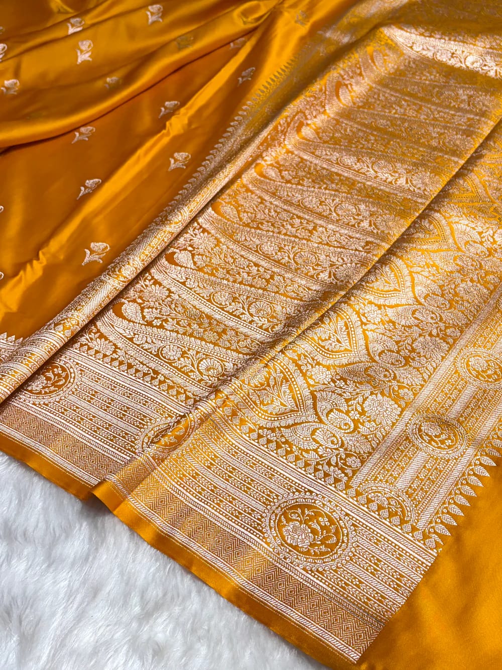 Yellow saree with intricate white patterns on a white background