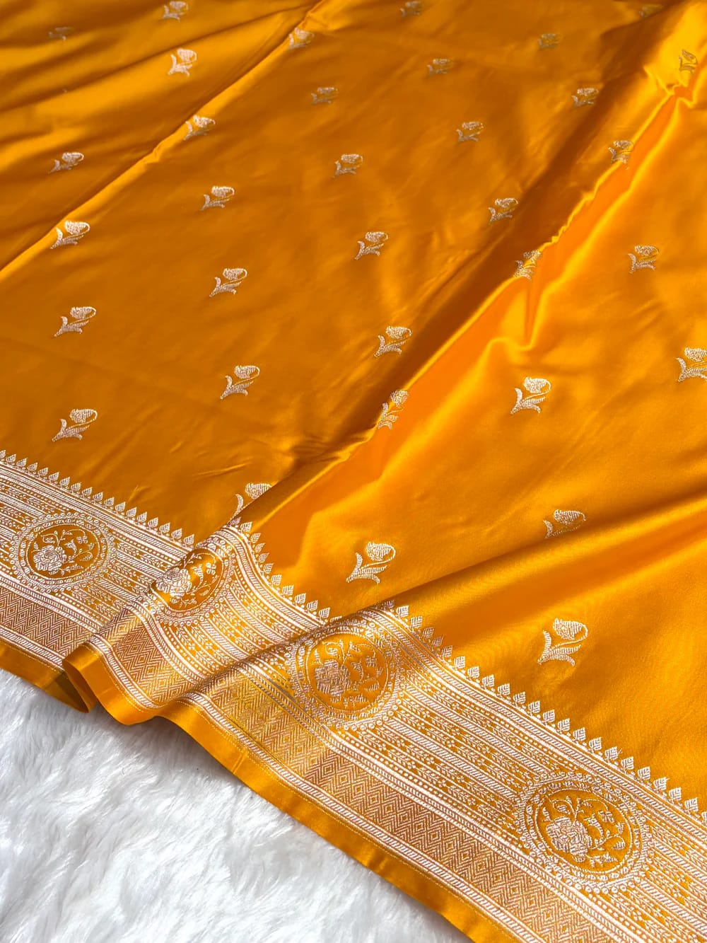 Yellow saree with intricate patterns on a white background
