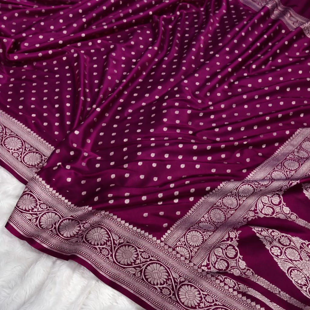 Purple saree with white polka dots and intricate gold border on a white background