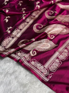 Purple fabric with intricate gold patterns on a white surface