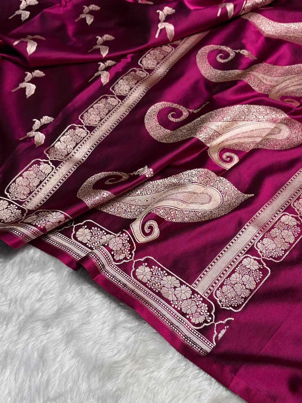 Purple fabric with intricate gold patterns on a white surface