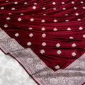 Maroon fabric with silver floral patterns on a white background