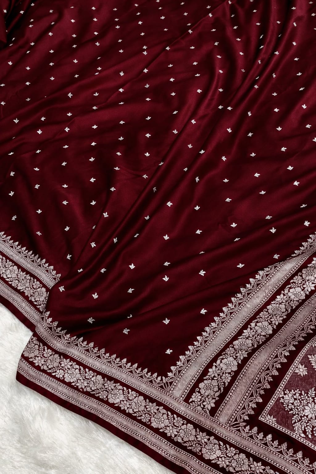 Maroon fabric with white embroidery on a white background