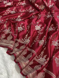 Red fabric with intricate gold embroidery on a white background