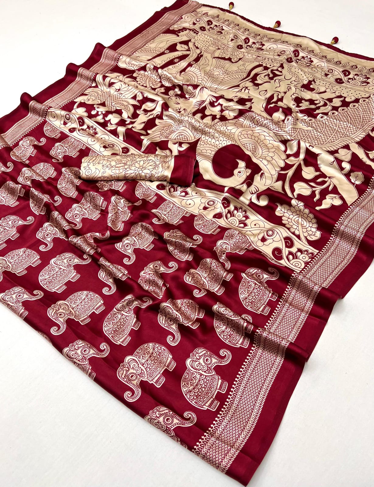 Maroon saree with gold elephant patterns on a white background
