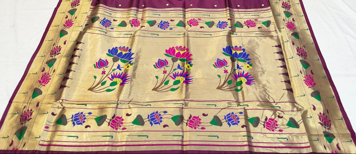 Purple saree with floral patterns on a fabric store background