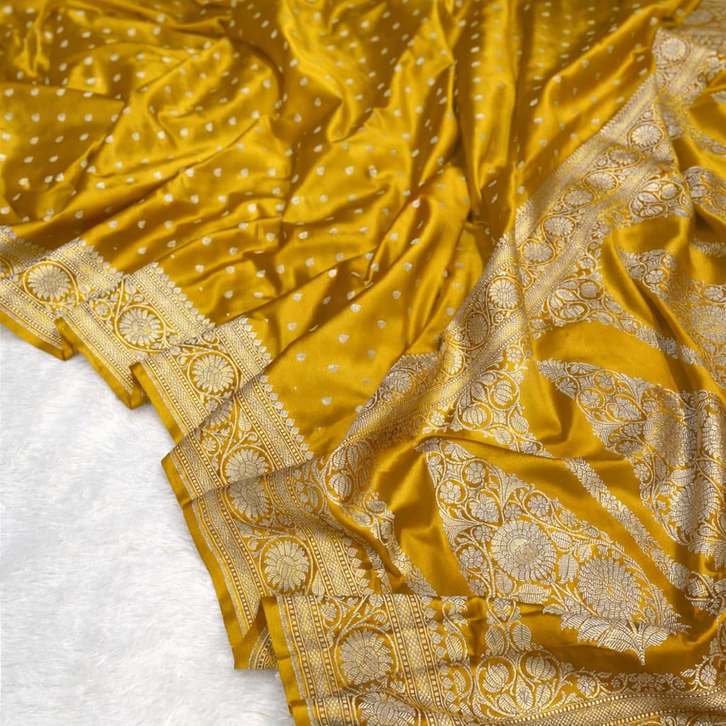 Yellow fabric with intricate gold patterns on a white background
