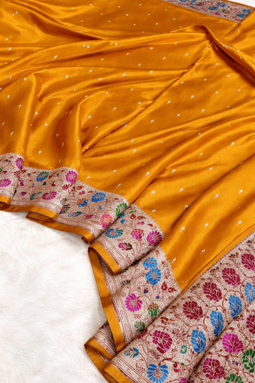 Yellow saree with floral patterns on a white background