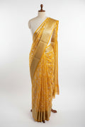 Yellow saree with white floral patterns on a dark surface