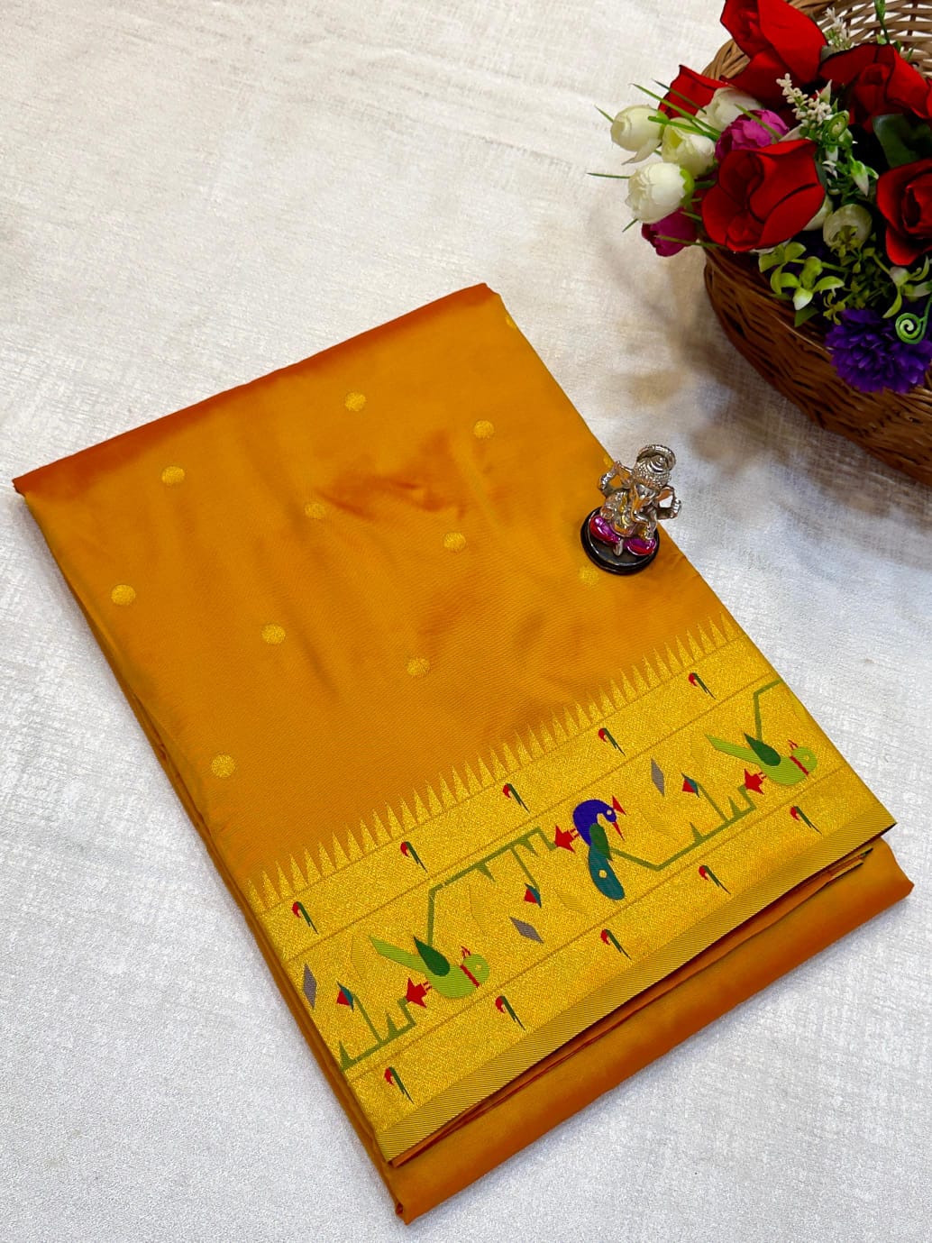 Yellow saree with intricate patterns on a white fabric background