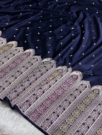 Navy blue fabric with intricate white embroidery on a light gray background