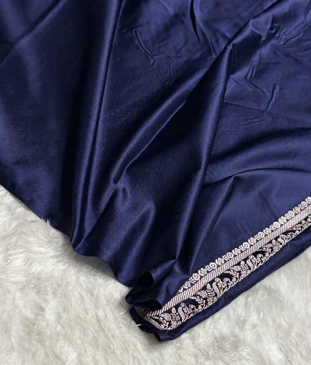 Navy blue fabric with intricate white embroidery on a white background