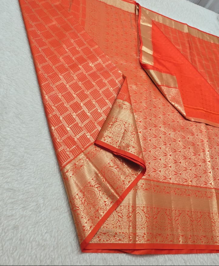 Orange saree with a gold border on a white surface