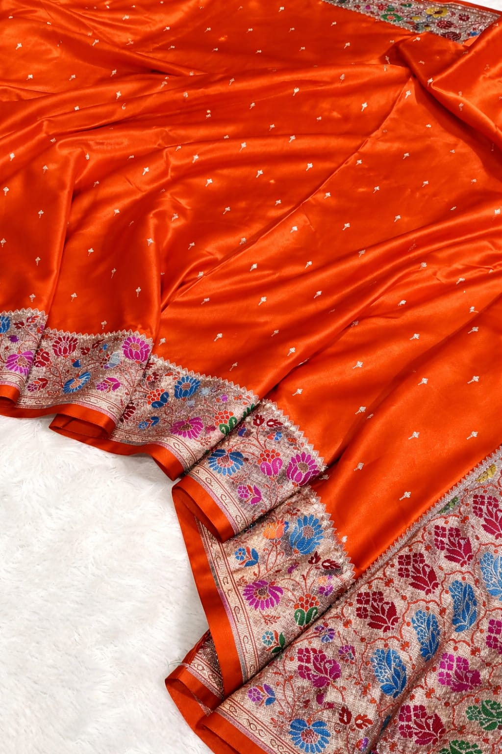 Orange saree with intricate patterns on a white background