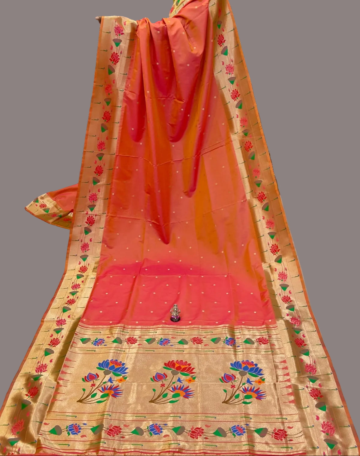Orange saree with floral patterns on a white background