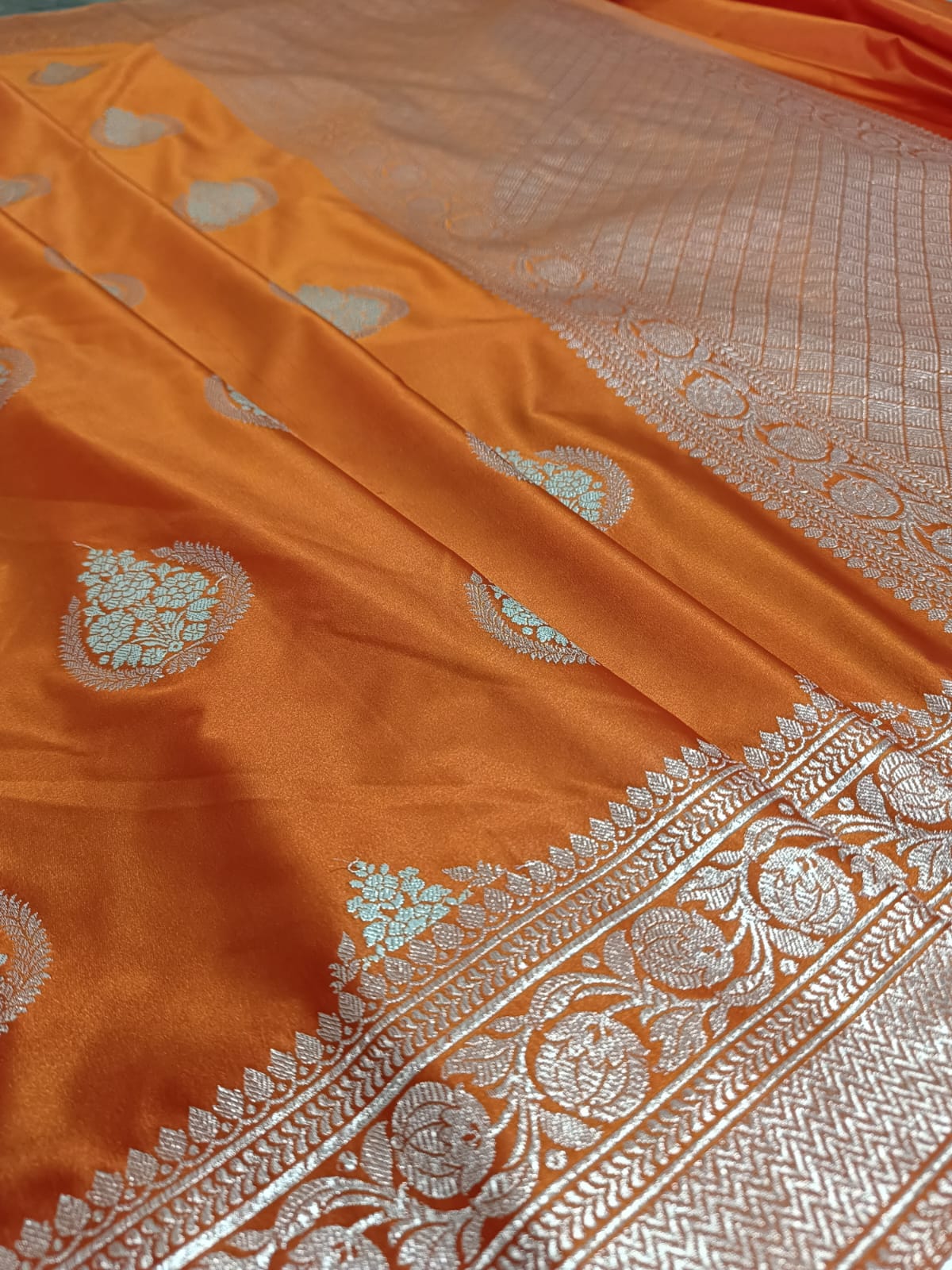 Orange saree with intricate silver patterns