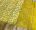 Yellow saree with floral patterns on a dark surface