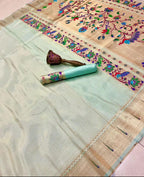 Saree with intricate embroidery and a matching green blouse on a neutral background