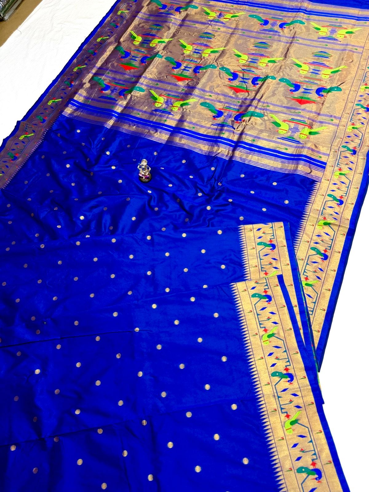 Blue saree with intricate patterns on a plain background