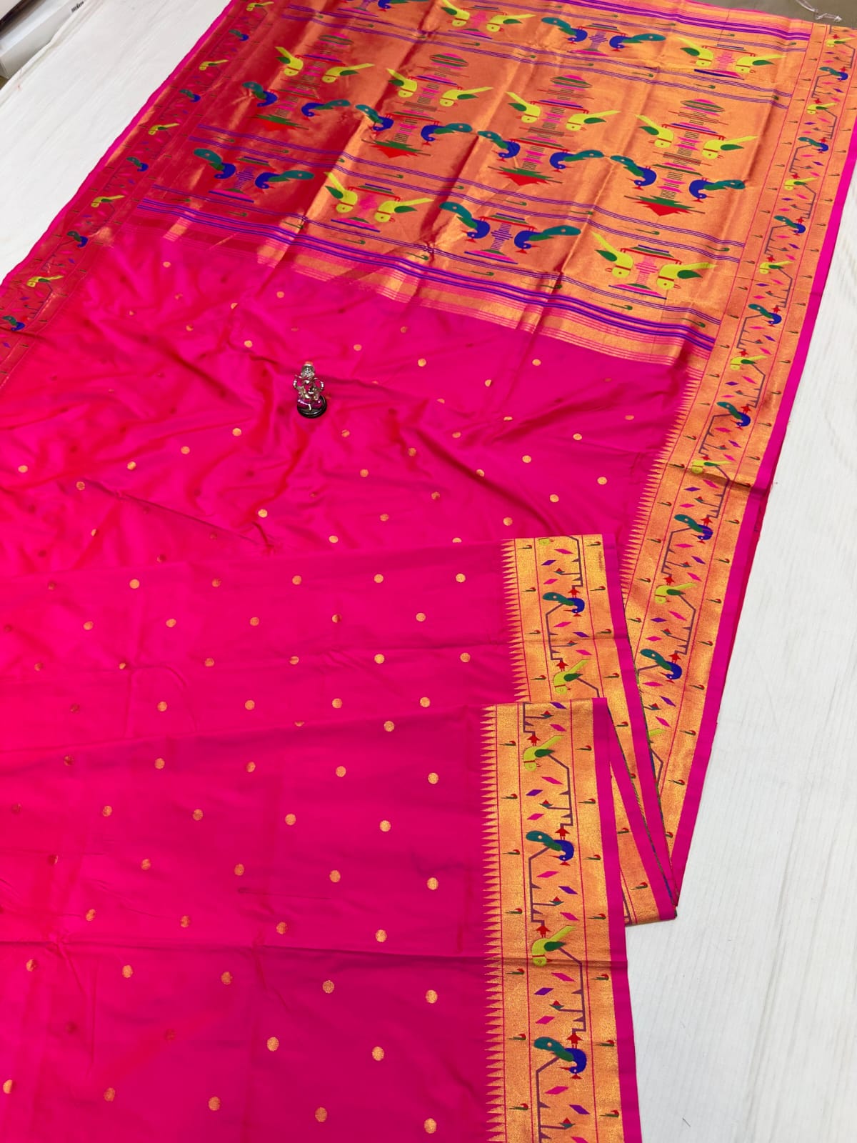 Pink saree with a colorful border on a white background