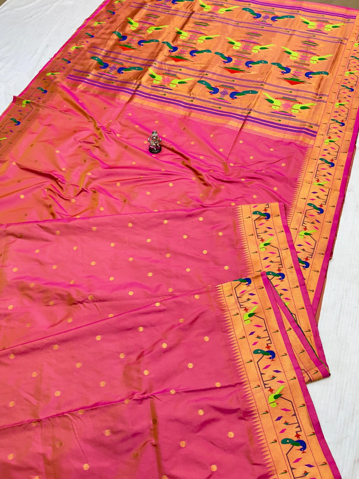 Pink saree with orange border on a white background