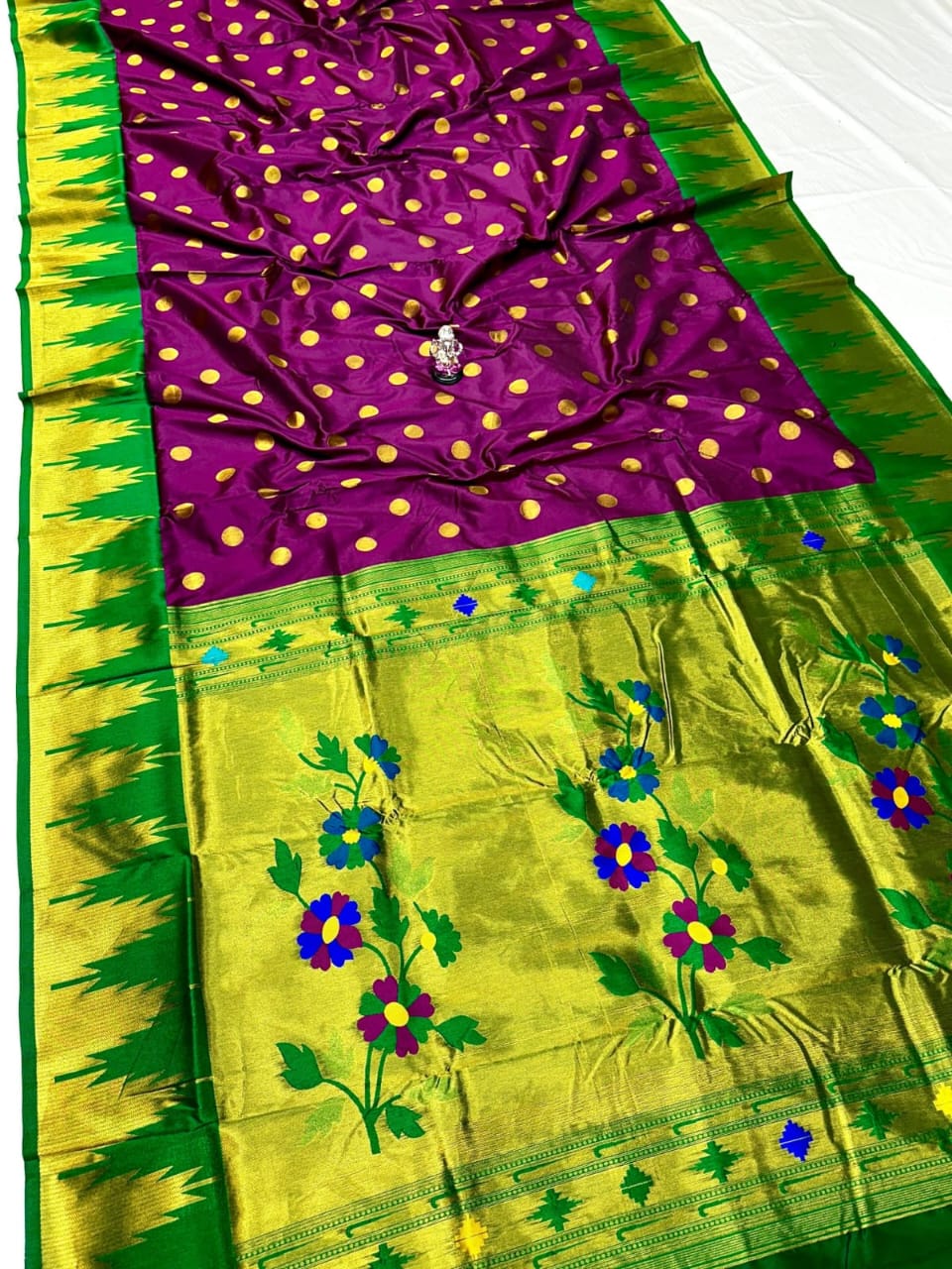 Purple saree with gold polka dots and green border with floral patterns