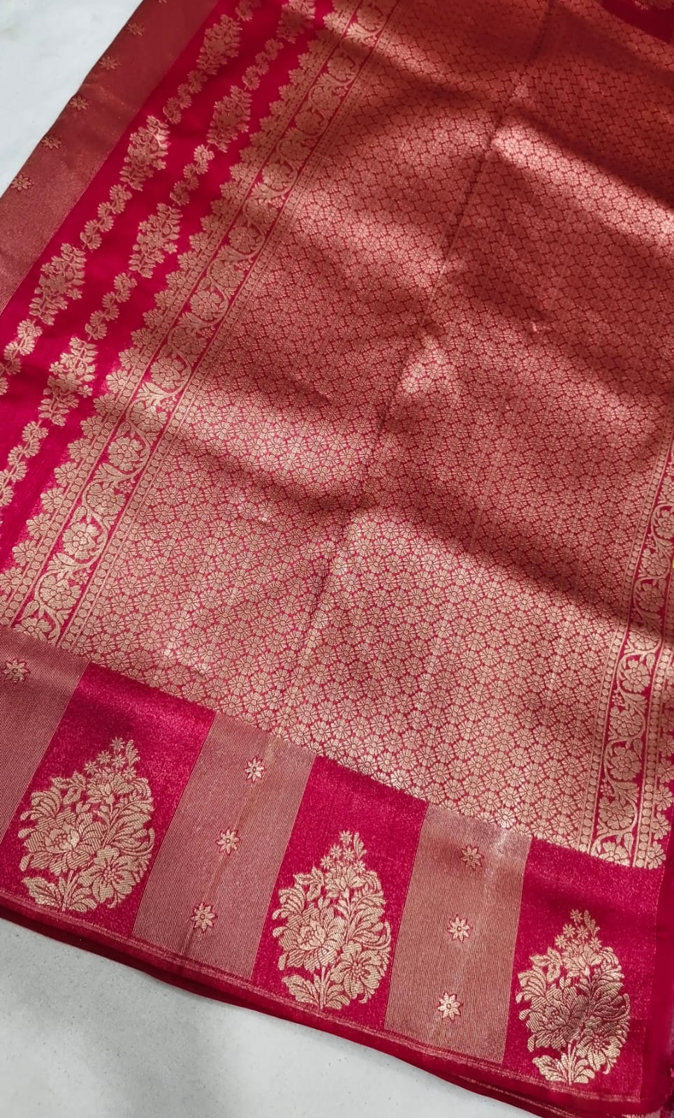 Red fabric with gold embroidery on a white background