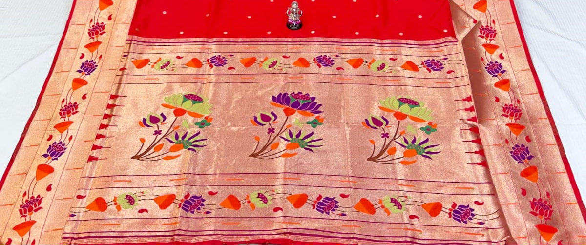 Red saree with floral patterns in a store setting