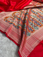 Red fabric with intricate paisley pattern on a white background