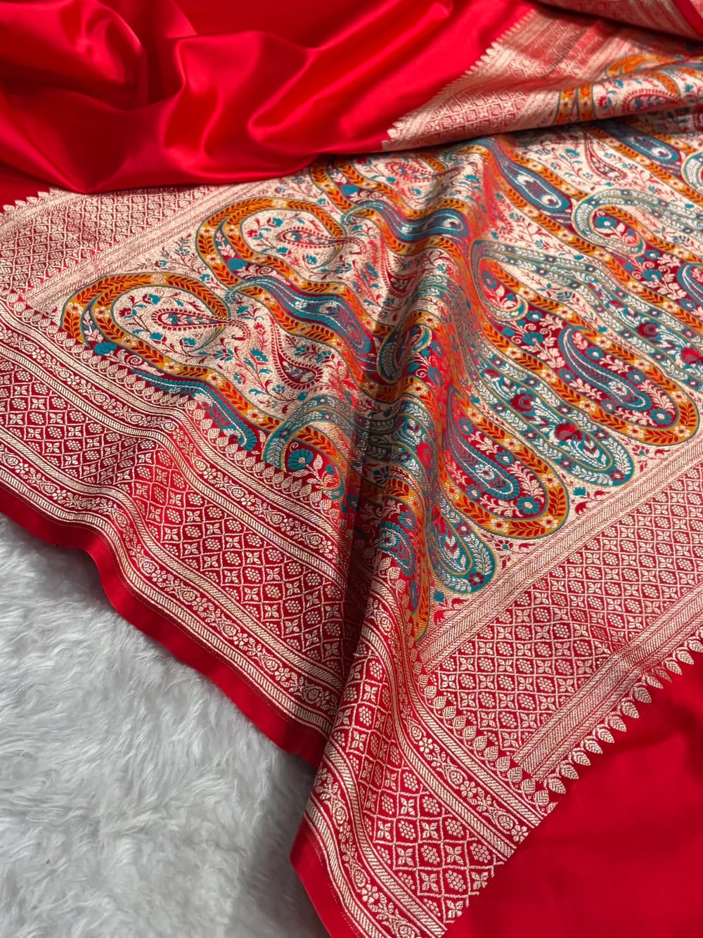 Red fabric with intricate paisley pattern on a white background