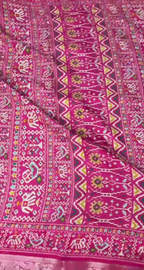Pink fabric with intricate white and multicolor patterns