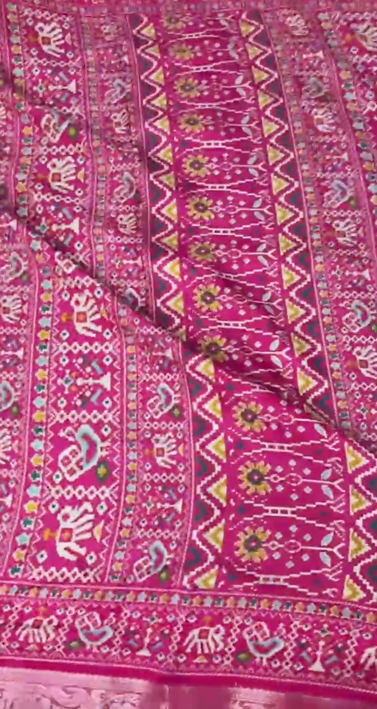 Pink fabric with intricate white and multicolor patterns
