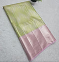 Green and pink fabric with a small plant and yellow flowers on a white surface