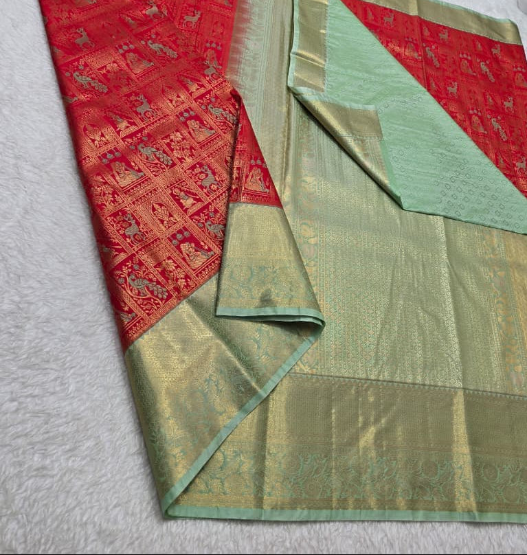 Red and green saree with floral decorations on a white background