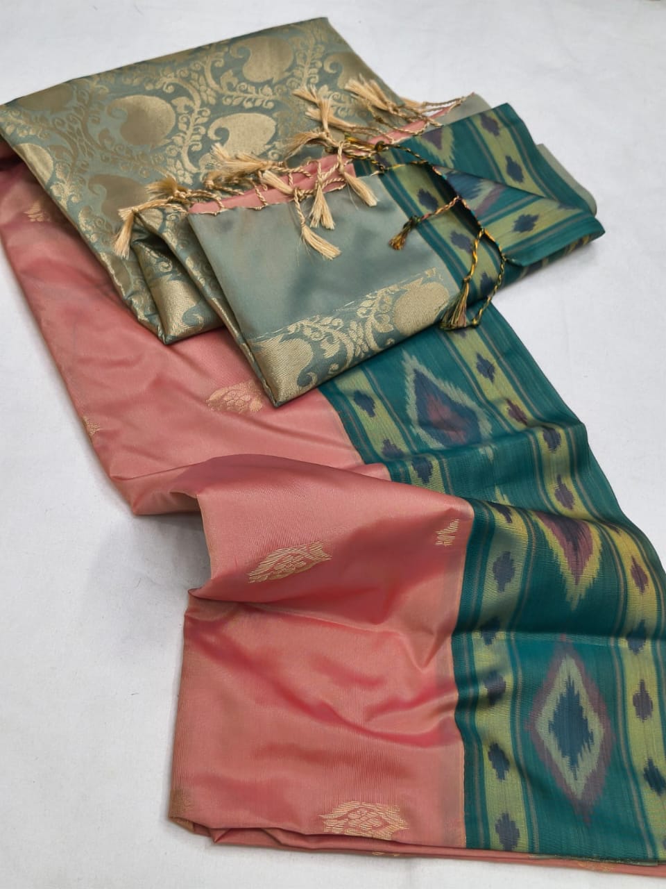 Two folded fabric pieces, one pink and one green with patterns, on a white background.
