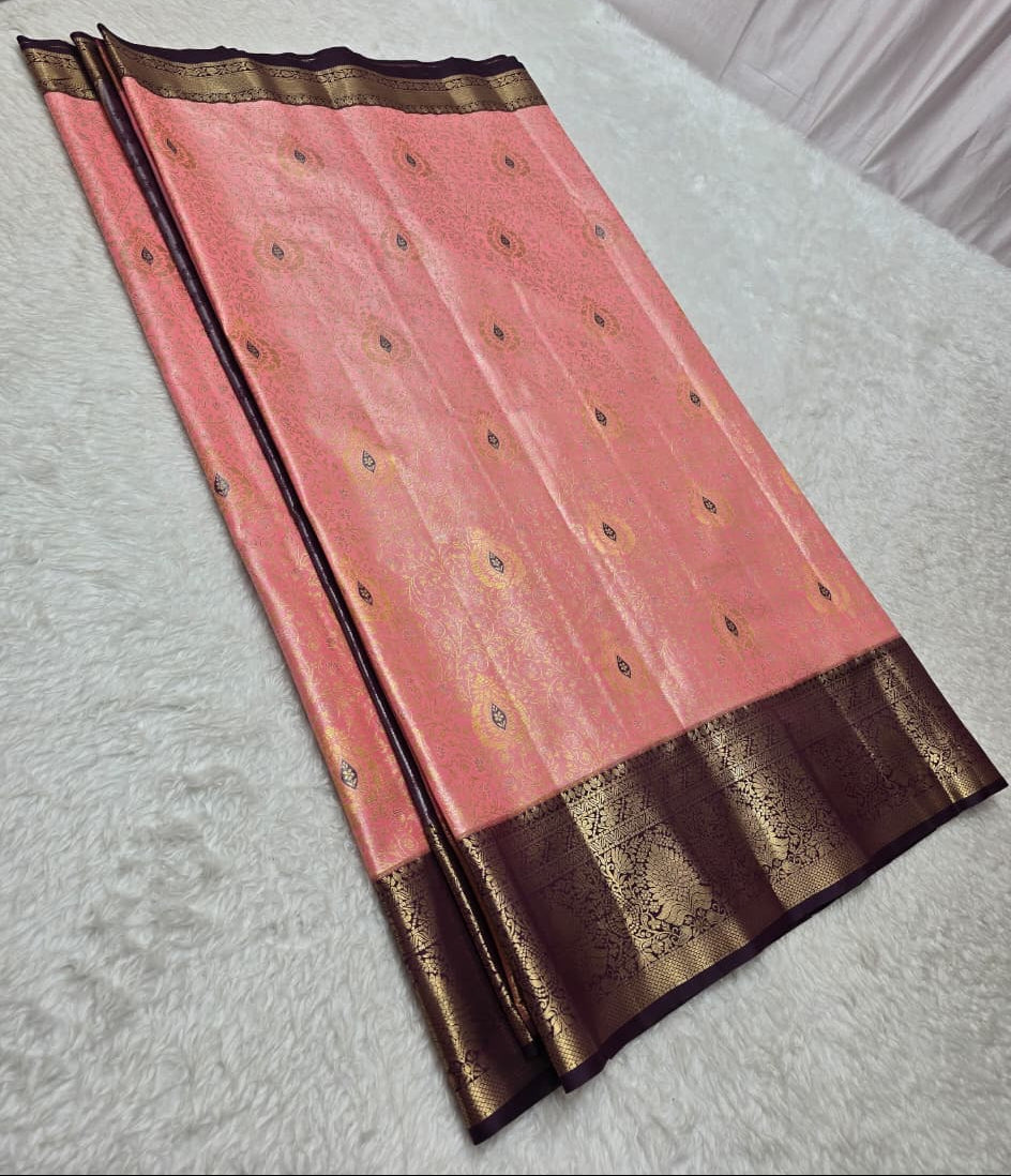 Pink saree with brown border on a light gray surface