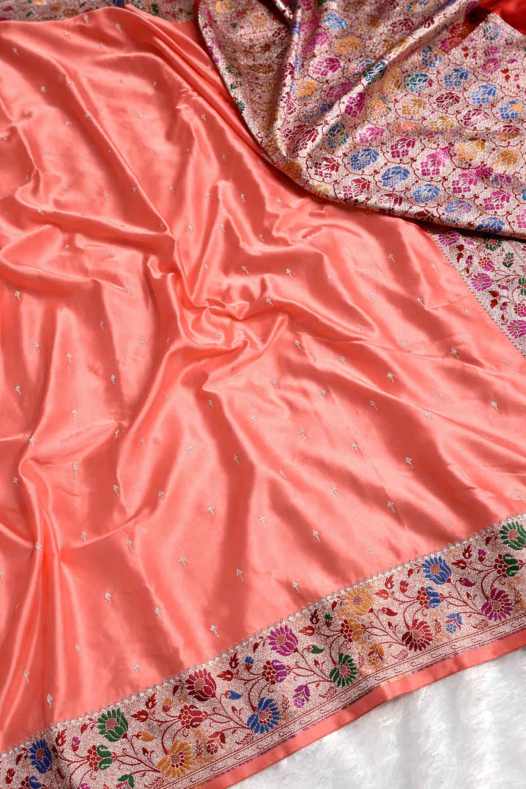 Peach fabric with floral embroidery on a white background