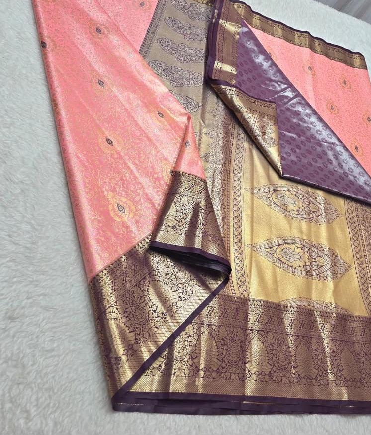 Traditional saree with pink and gold patterns on a white surface