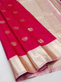 Pink saree with white border on a light gray background