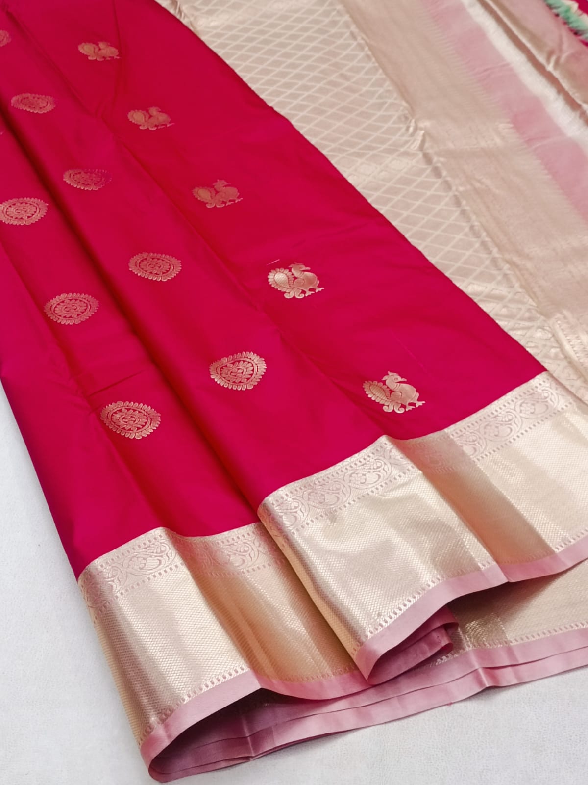 Pink saree with white border on a light gray background