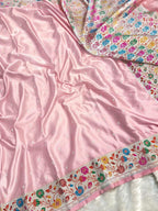 Pink fabric with floral embroidery on a white background