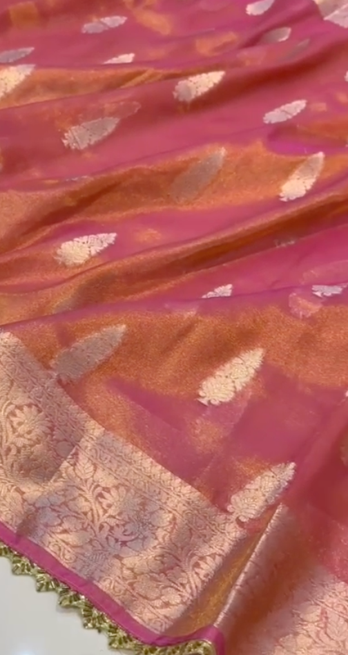 Close-up of a pink saree with gold patterns
