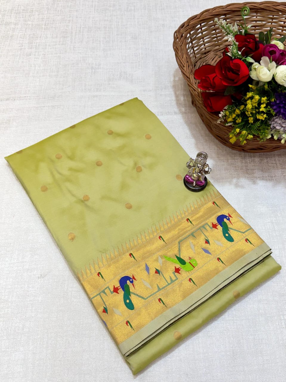 Green saree with floral design on a white fabric background