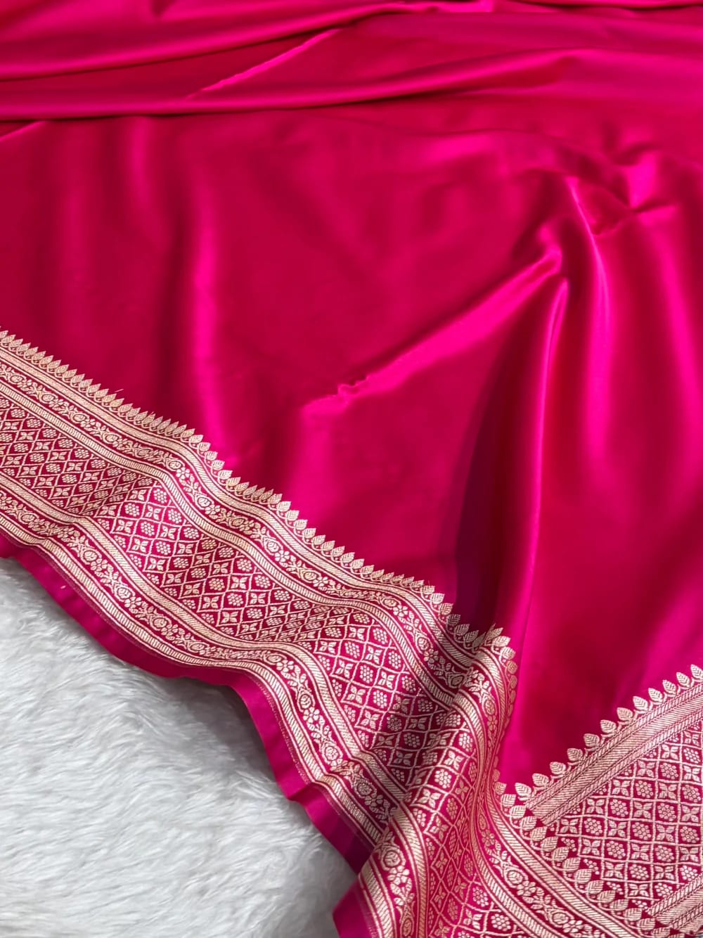 Red fabric with intricate white patterns on a white background