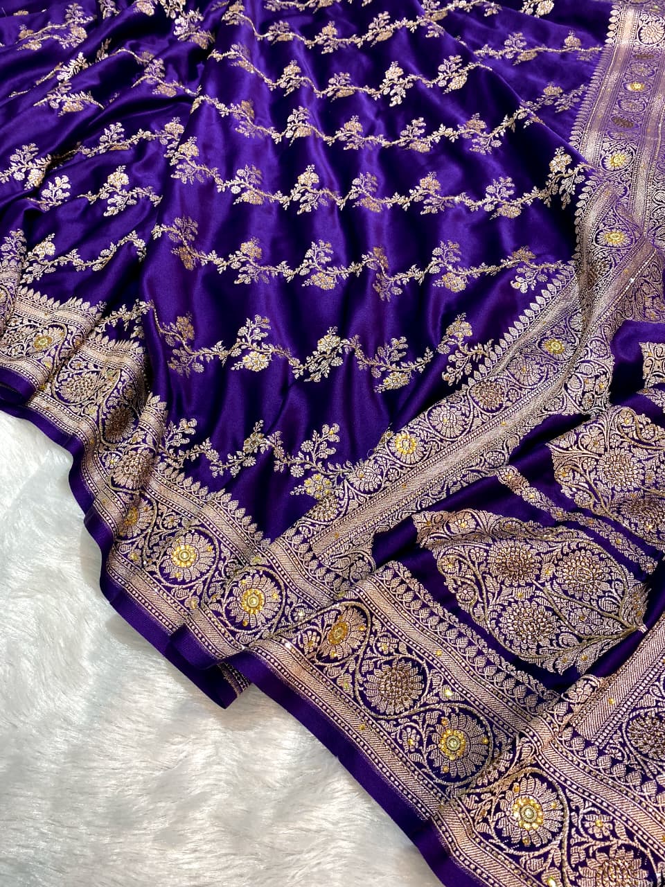 Purple saree with intricate gold and silver embroidery on a white background