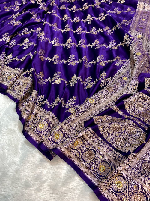 Purple saree with intricate gold and silver embroidery on a white background